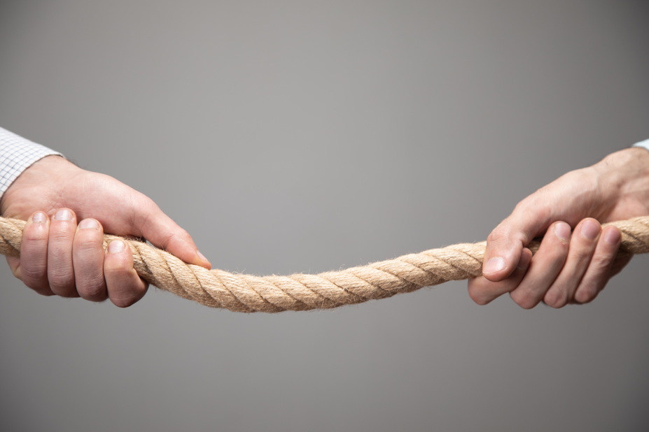 Zwei Hände ziehen an einem Strang, eine links, eine rechts