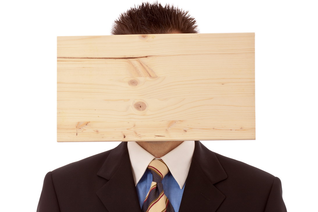 Ein Brett verdeckt das Gesicht eines Geschäftsmanns