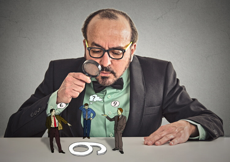 DEESKALATIONSTRAINING FÜR MITARBEITER Ein Geschäftsmann schaut durch eine Lupe. Auf dem Tisch vor ihm sind 3 kleine Geschäftsmänner zu sehen, die miteinander diskutieren.